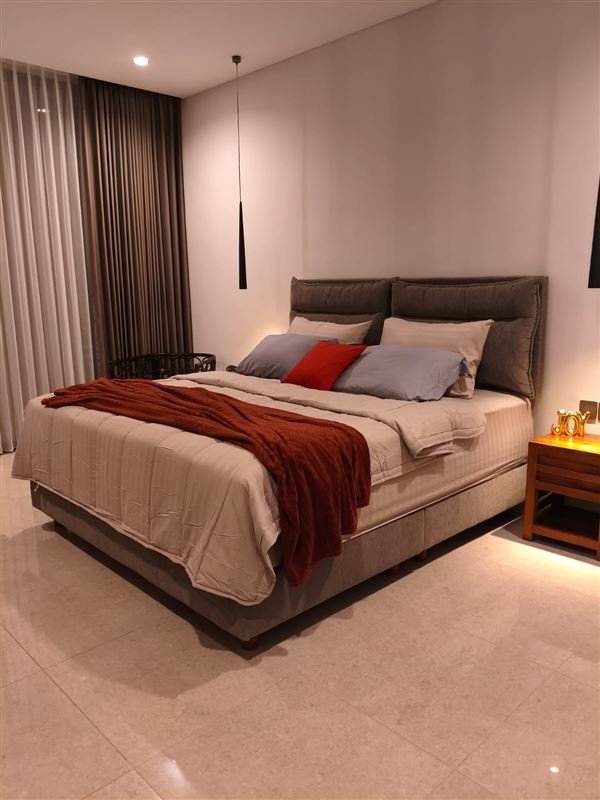 Bedroom with upholstered bed and blackout curtains
